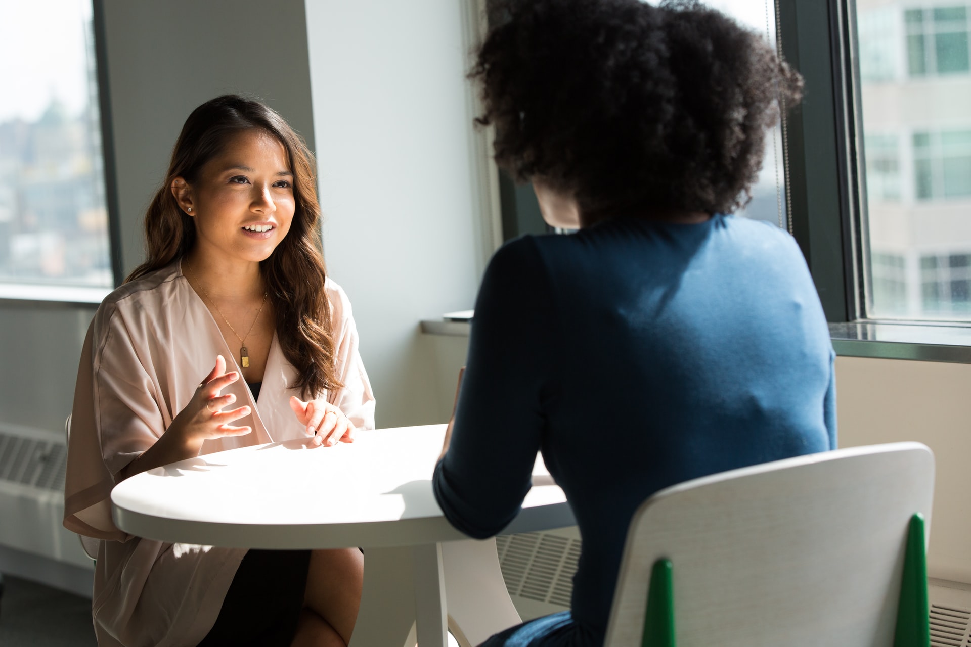 An image of two women talking at a table